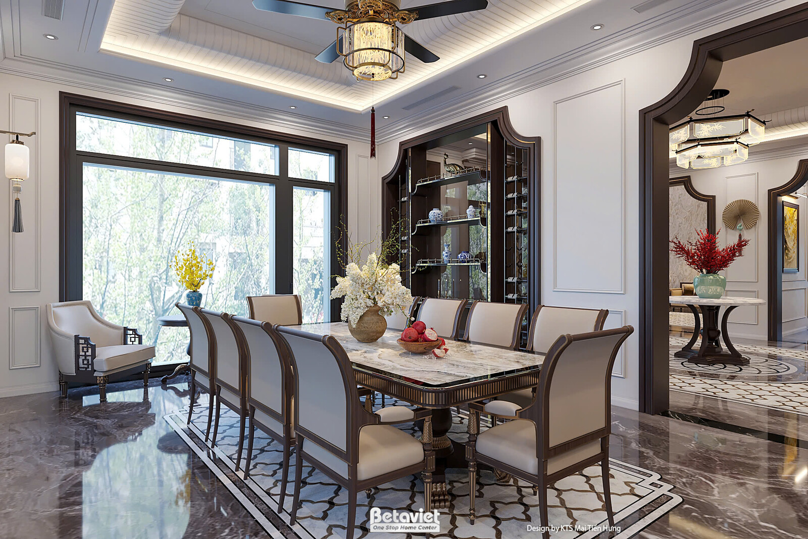 Bàn tiệc dài kê giữa phòng với ghế bọc da nâu, tủ kính/kệ trang trí bên cạnh, chậu cây và bình hoa đỏ điểm nhấn, sàn đá ho…
